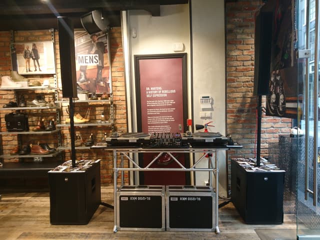 DJ booth with turntables, mixer and loudspeakers at a festive shop opening