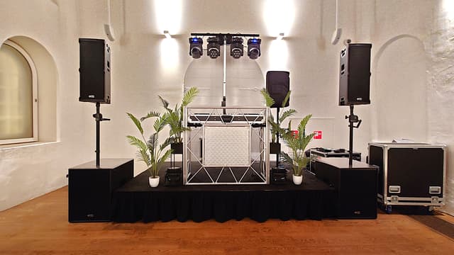 DJ-opstelling met podium, luidsprekers en verlichting