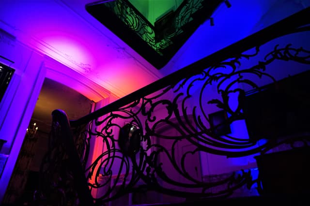 Monumentale trap uitgelicht met roze, paarse, blauwe en groene sfeerverlichting