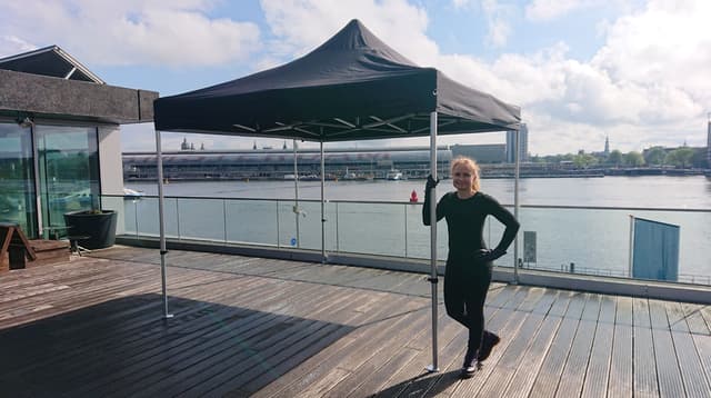 Chantal beside a black marquee overlooking the IJ