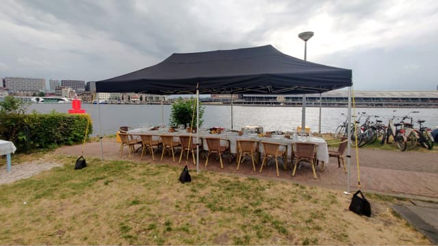 Lange gedekte eettafel op een externe locatie aan het water