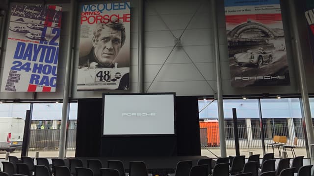 Presentatieopstelling met projectiescherm in een Porsche-showroom