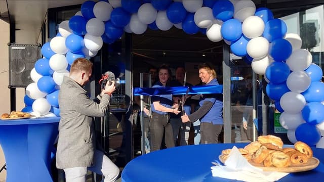 Fotograaf legt een feestelijke opening onder een ballonnenboog vast
