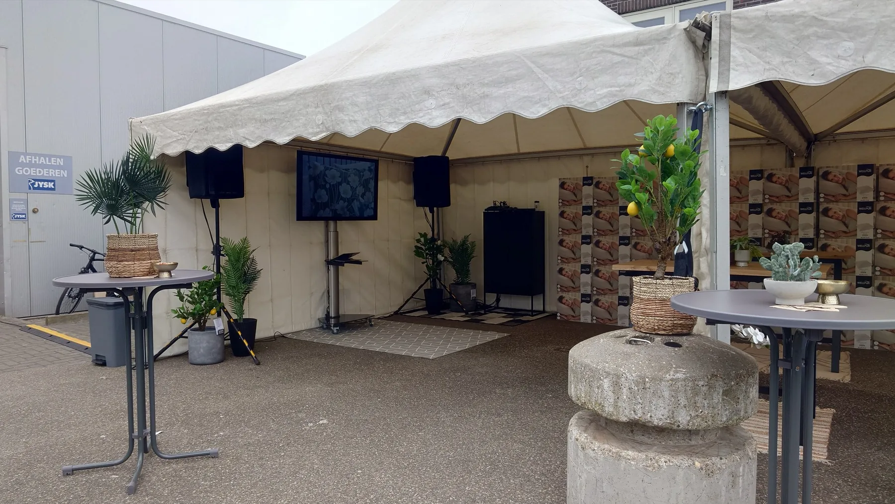 Marquee with audio-visual equipment, plants and standing tables
