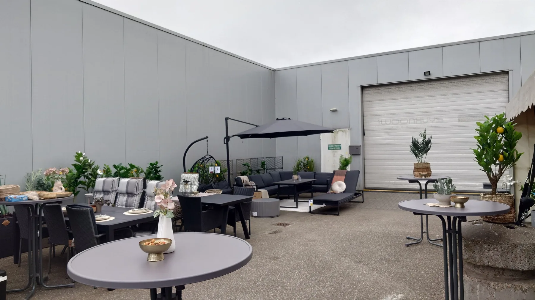 Outdoor space with lounge furniture, standing tables and greenery