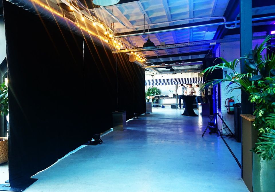 Zwarte pipe and drape in een industriële eventruimte