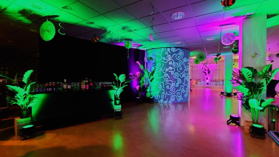Event venue with plants, lighting and standing tables